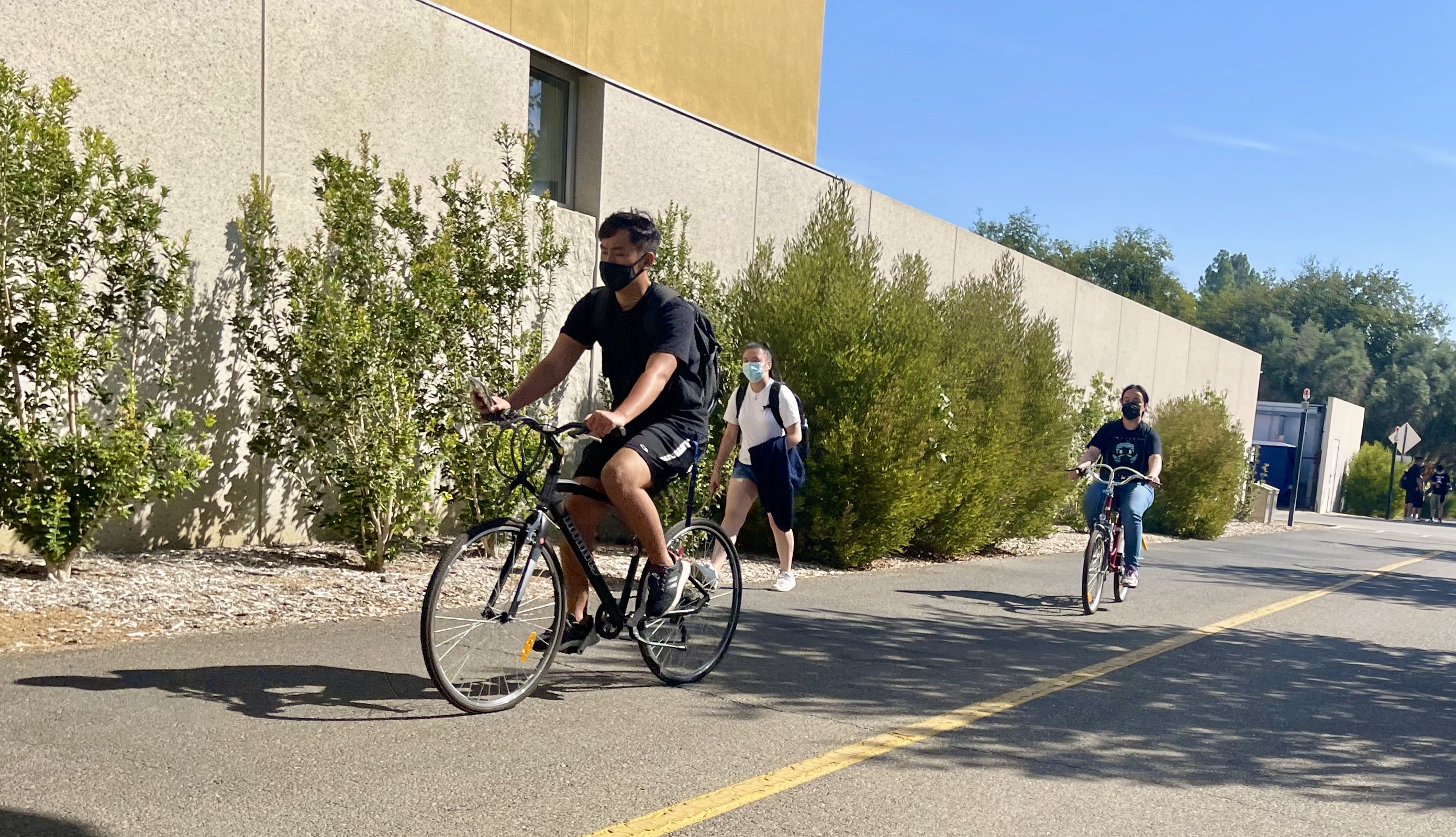 students riding bikes on campus