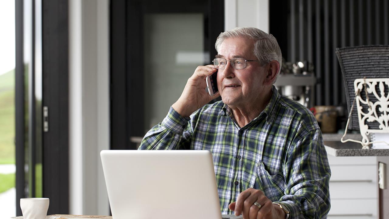 adult male senior on computer and phone