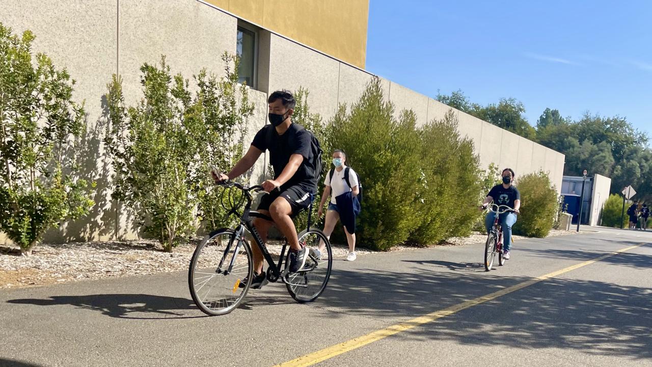 students riding bikes on campus