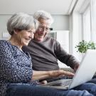 happy senior couple on computer