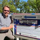 Land Use and Planning Certificate Program grad Lucas Frerichs poses next to a ballot box