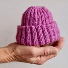 image of hand holding knitted hat
