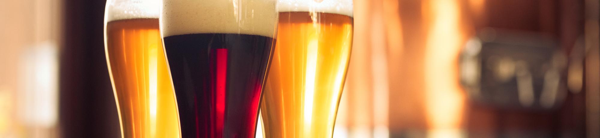 three glasses of different types of beer